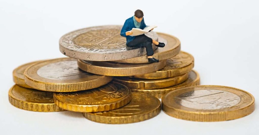 Homme lit sur un tas de pièces de monnaie